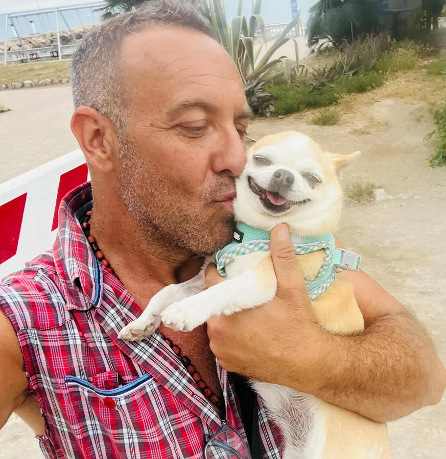 Eduardo Mangas, especialista en comportamiento canino, abrazando a un Chihuahua en Sitges